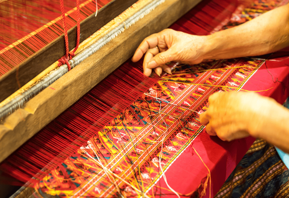 Colorful displays of handmade crafts, traditional textiles, and local spices fill the bustling Pho Doan Market (Source: Canva)